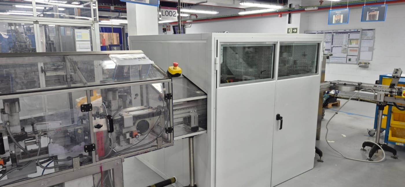 Una máquina, una línea de producción o una instalación supera el límite Cabina acústica instalada junto a una línea de producción en una nave industrial