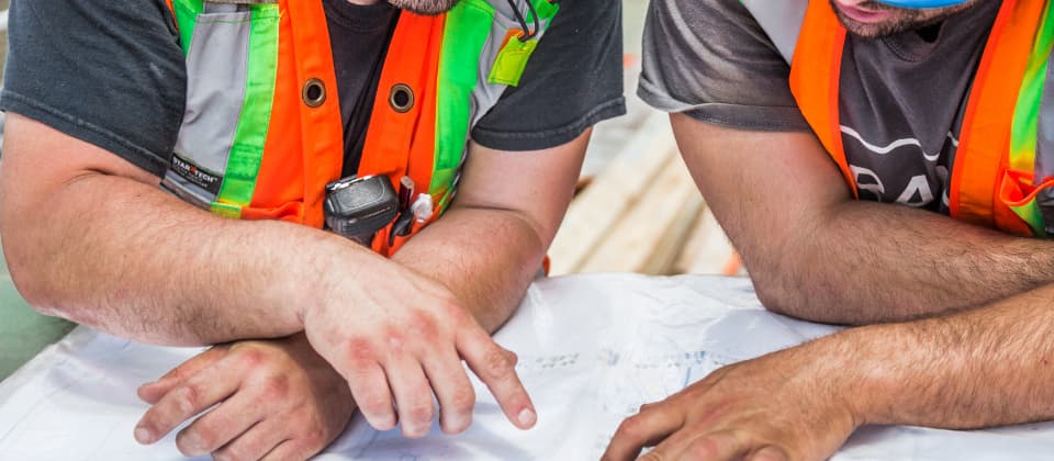 Equipo técnico revisando planos de un proyecto de medidas correctoras acústicas en obra