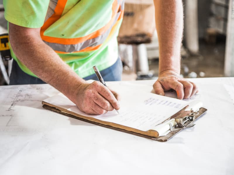 Técnico redactando el proyecto de medidas correctoras acústicas sobre los planos de la instalación