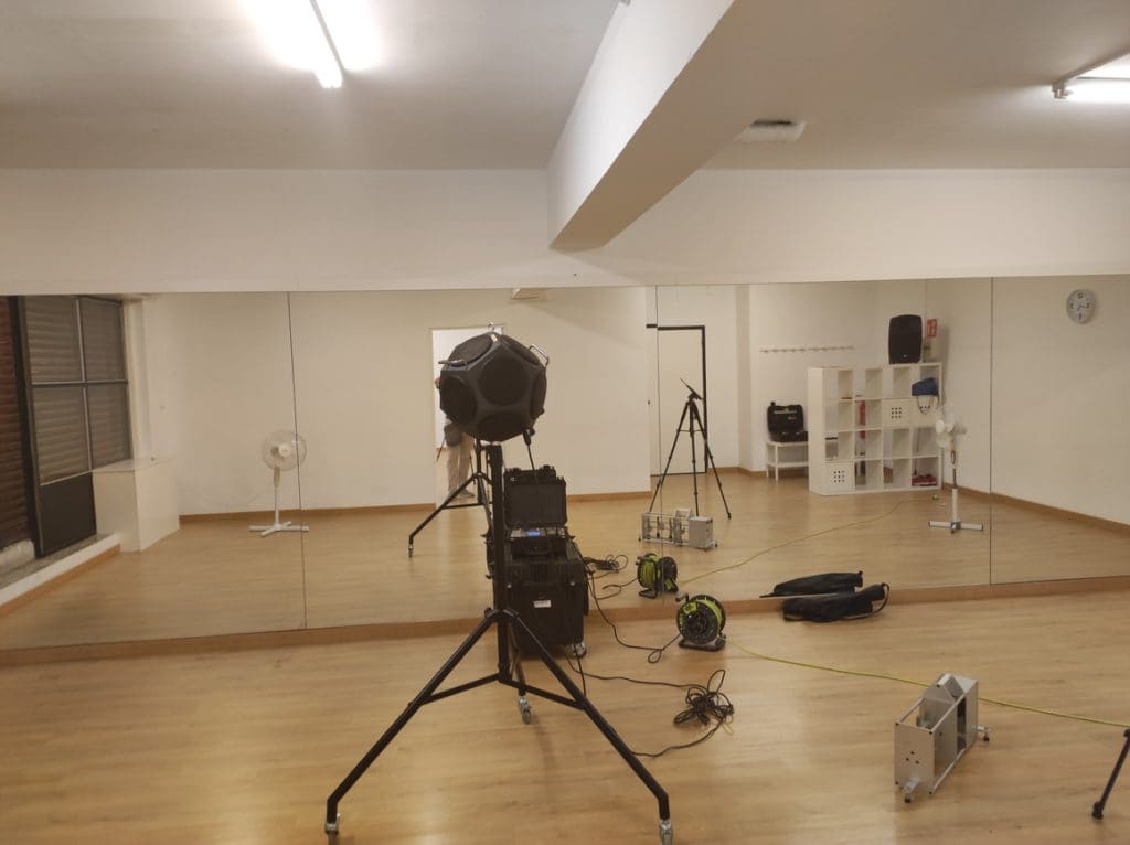 Estudios y salas de ensayo Sala de ensayo diáfana durante una medición acústica con fuente sonora y sonómetro
